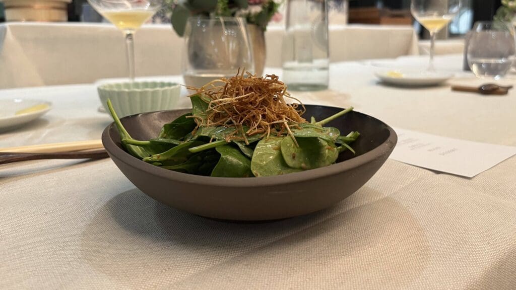 Babyspinat Salat mit einer leichten Erdnussauce getoppt mit frittierten Frühlingszwiebeln. © Milena Hartmann